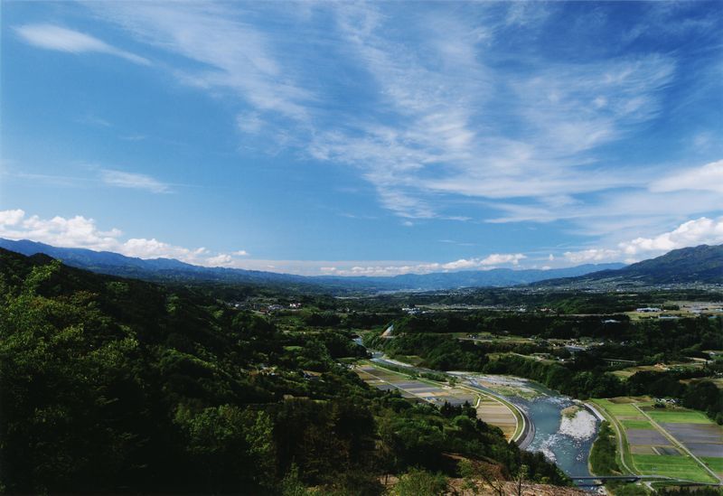 晴天の空と天竜川沿いの田園風景の写真です