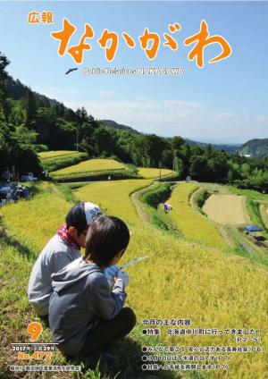 広報なかがわ2017年９月号表紙、棚田の稲刈りを手伝う子どもの写真です