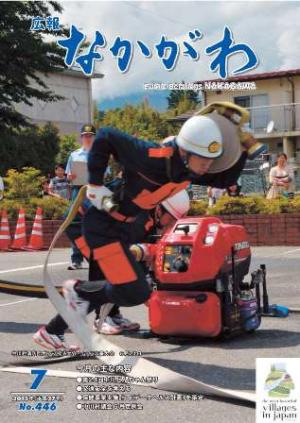 広報なかがわ2015年７月号表紙、中川村消防団操法大会でホースを担いで走る団員の写真です